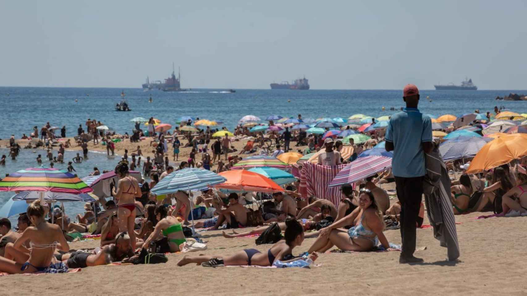 Cientos de personas disfrutan de la playa durante un fin de semana de ola de calor en Barcelona