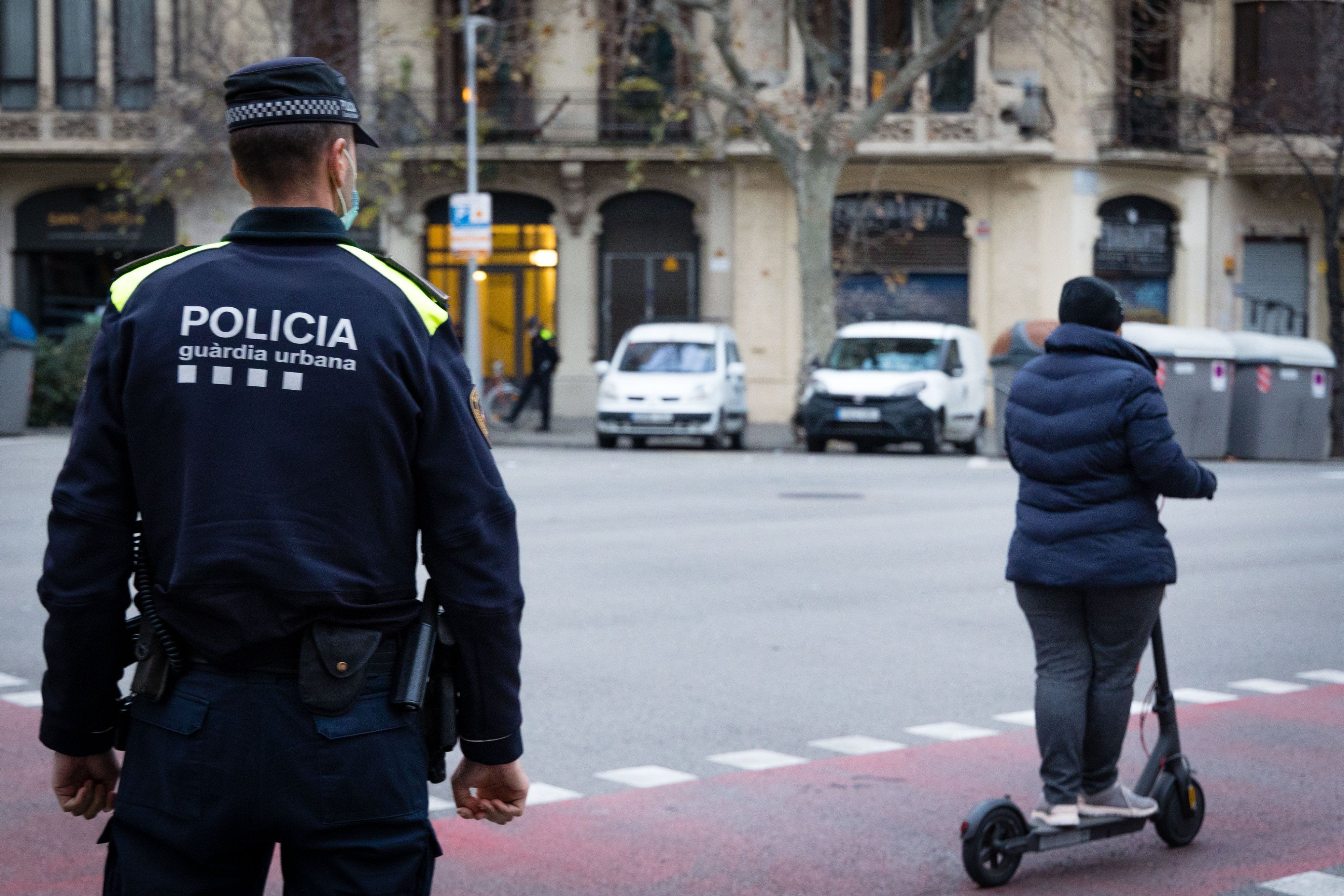 Un agente de la Guardia Urbana junto a un conductor de un patinete eléctrico / GUARDIA URBANA