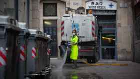 Trabajadora de la limpieza, ataviada con su uniforme de trabajo, realizando una desinfección de contenedores / EUROPA PRESS