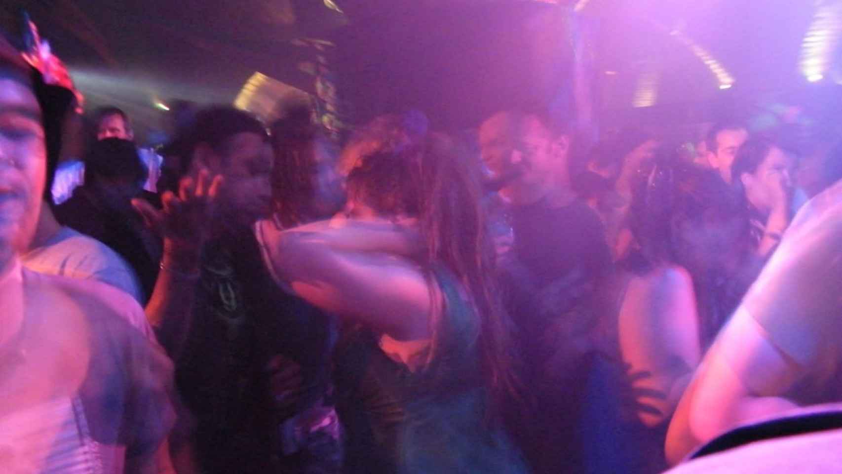 Interior de una discoteca con decenas de personas bailando en su interior