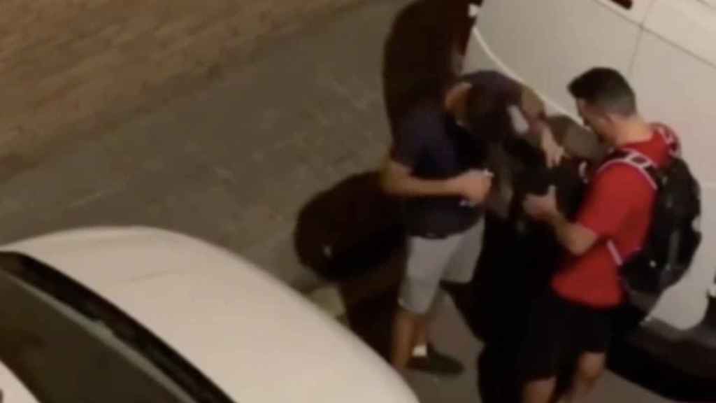Dos hombres escudriñan una mochila en el barrio de la Barceloneta el 29 de julio