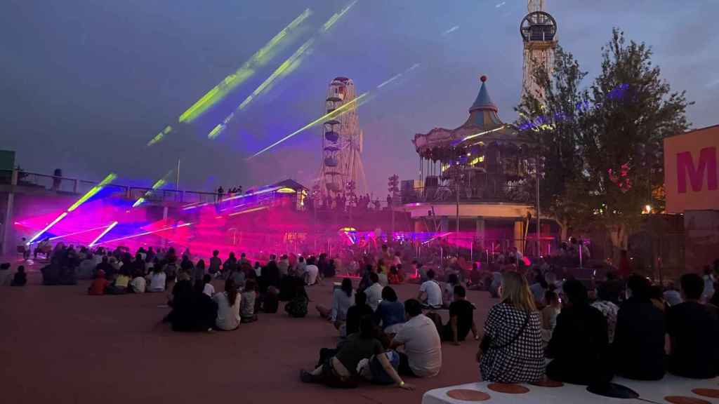 Personas disfrutando del espectáculo 'Laser Show' en el Tibidabo, uno de los mejores planes de agosto en Barcelona / TIBIDABO