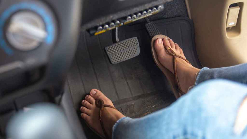 Un conductor utilizando las chanclas como calzado para conducir