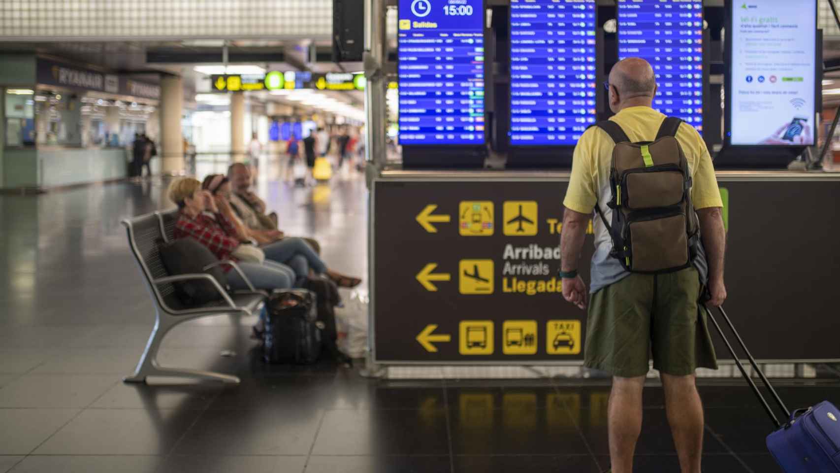 Un hombre mira un panel de llegadas y salidas en el Aeropuerto Josep Tarradellas Barcelona-El Prat / EUROPA PRESS