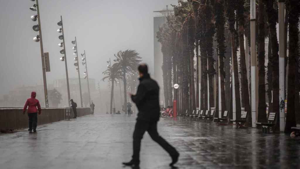 Diferentes personas en el paseo marítimo de Barcelona poco después de llover / EP