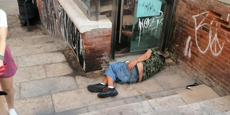 Una persona duerme sobre el suelo y restos de orina en un rincón del parque / CEDIDA