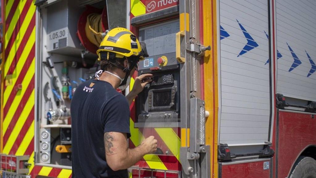 Efectivo de los bomberos junto a un camión se prepara para acudir a un incendio