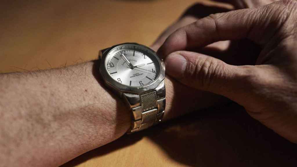 Un hombre cambia la hora en su reloj en una imagen de archivo