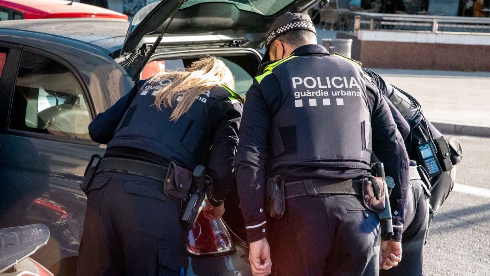 Agentes de la Guardia Urbana durante el registro de un vehículo en una imagen de archivo / GUB