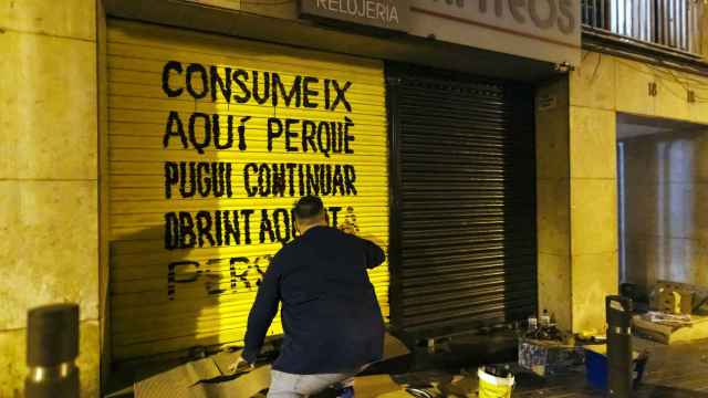El artista Javirroyo pintando un comercio del Carmel /Una treintena de tiendas de los barrios de Can Baró y el Carmel de Barcelona han despertado este domingo con grafitis en