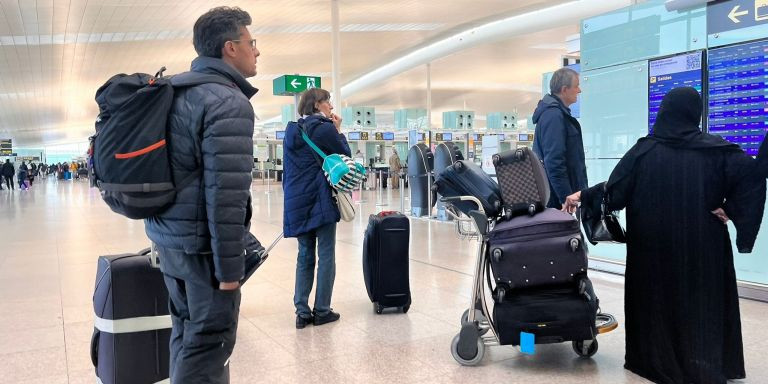 Pasajeros mirando las pantallas informativas en el Aeropuerto Barcelona-El Prat / ÁNGELA VÁZQUEZ