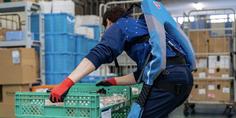 Un trabajador del sector industrial utilizando el exoesqueleto para levantar cajas / HEALTHY SUITS