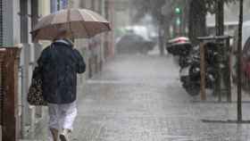 Una mujer se protege de la lluvia en Barcelona