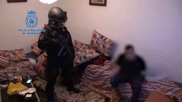 Un agente de la Policía Nacional junto a uno de los detenidos en el dispositivo policial, en el que participaron más de un centenar de efectivos / POLICÍA0 NACIONAL