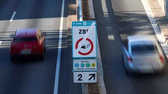 Dos vehículos circulan junto a un cartel de la Zona de Bajas Emisiones / EFE