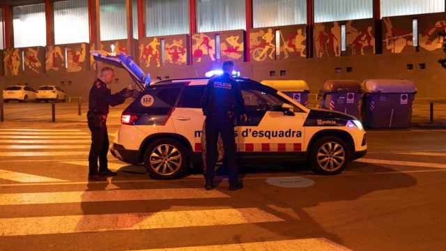 Dos agentes de los Mossos d'Esquadra en un coche patrulla en Badalona / LUIS MIGUEL AÑÓN