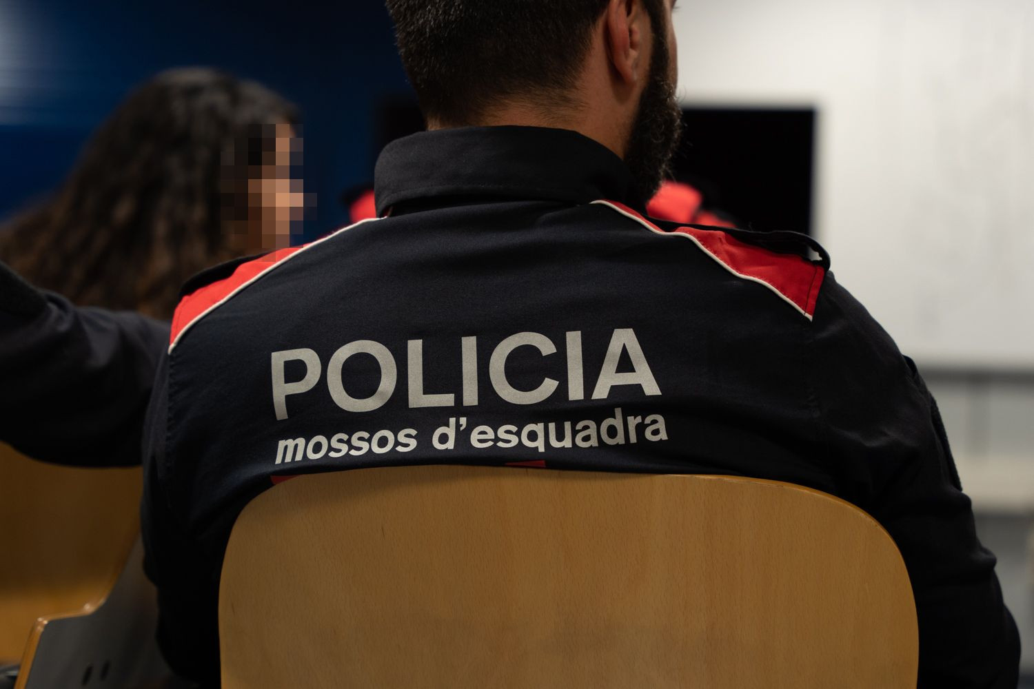 Un agente de los Mossos d'Esquadra durante el briefing en la comisaría de Badalona / LUIS MIGUEL AÑÓN