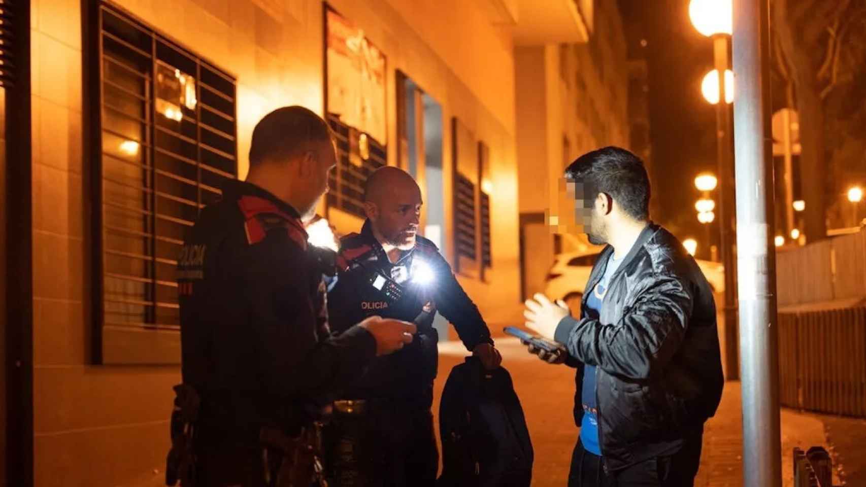 Dos agentes de los Mossos d'Esquadra identifican a un sospechoso en Badalona / LUIS MIGUEL AÑÓN