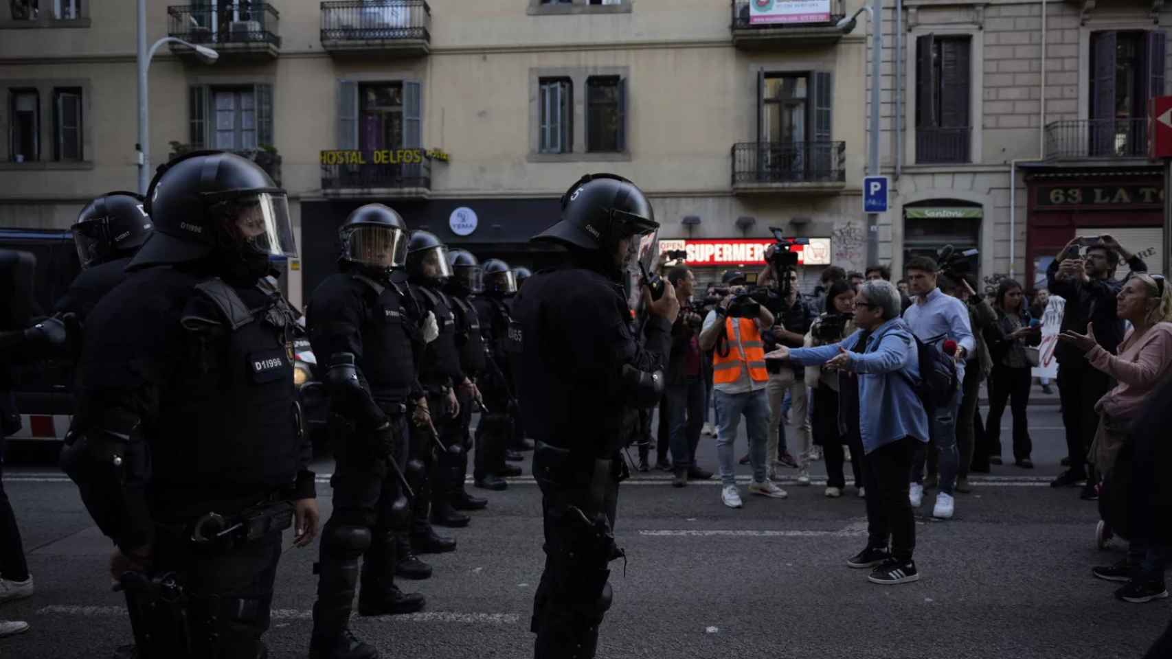 Manifestantes pro-okupación ante un cordón policial en la plaza de Universitat / LUIS MIGUEL AÑÓN