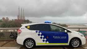 Un coche de la Policía Local de Sant Adrià con las Tres Chimenea de fondo / ARCHIVO