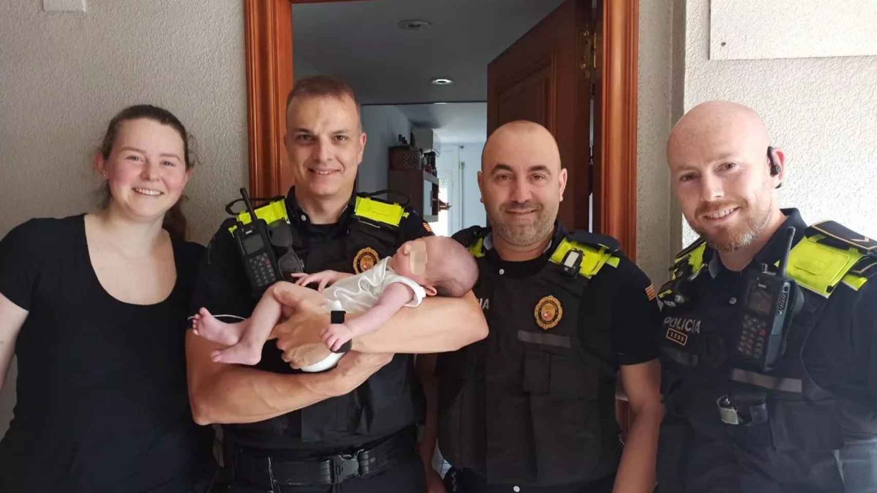 Los agentes de la Policía Municipal de Terrassa con la pequeña Adara y su madre tras el incendio / TWITTER