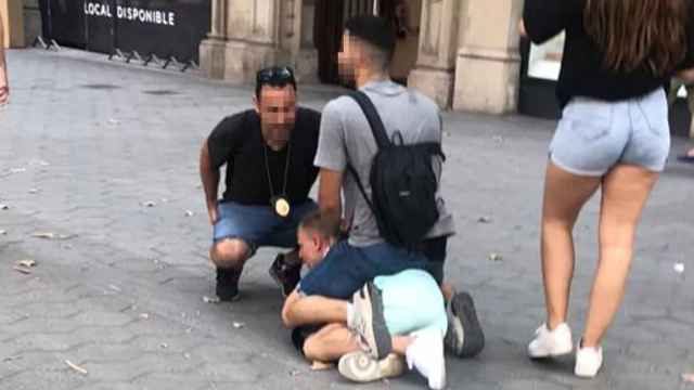 El ladrón inmovilizado, por dos policías en Paseo de Gràcia / MA
