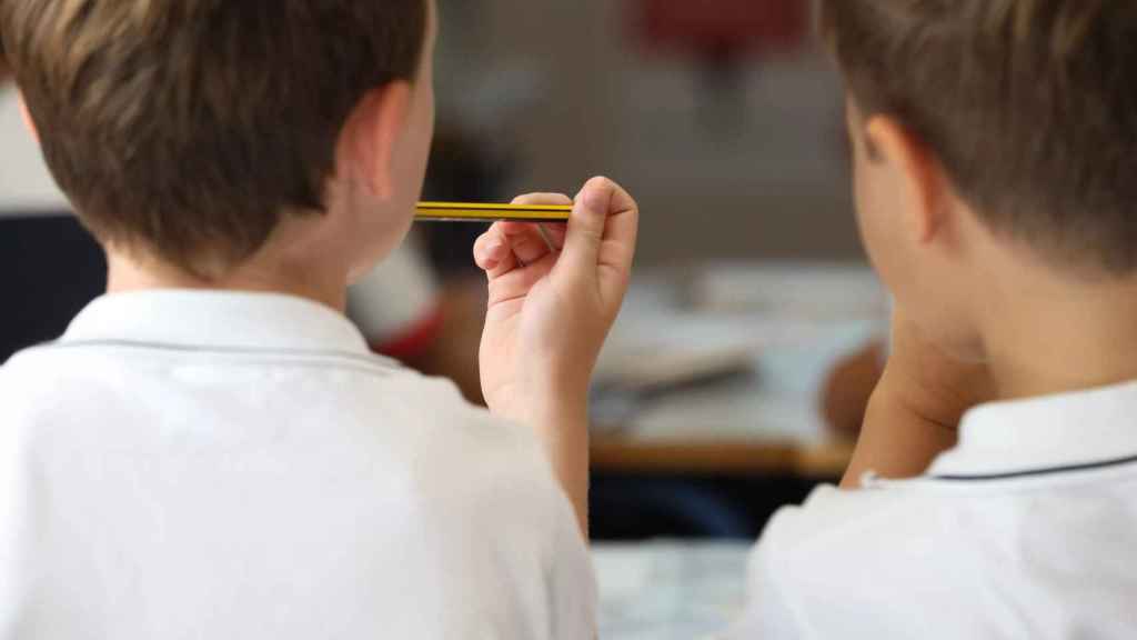 Un niño sostiene un lápiz en el aula de un colegio