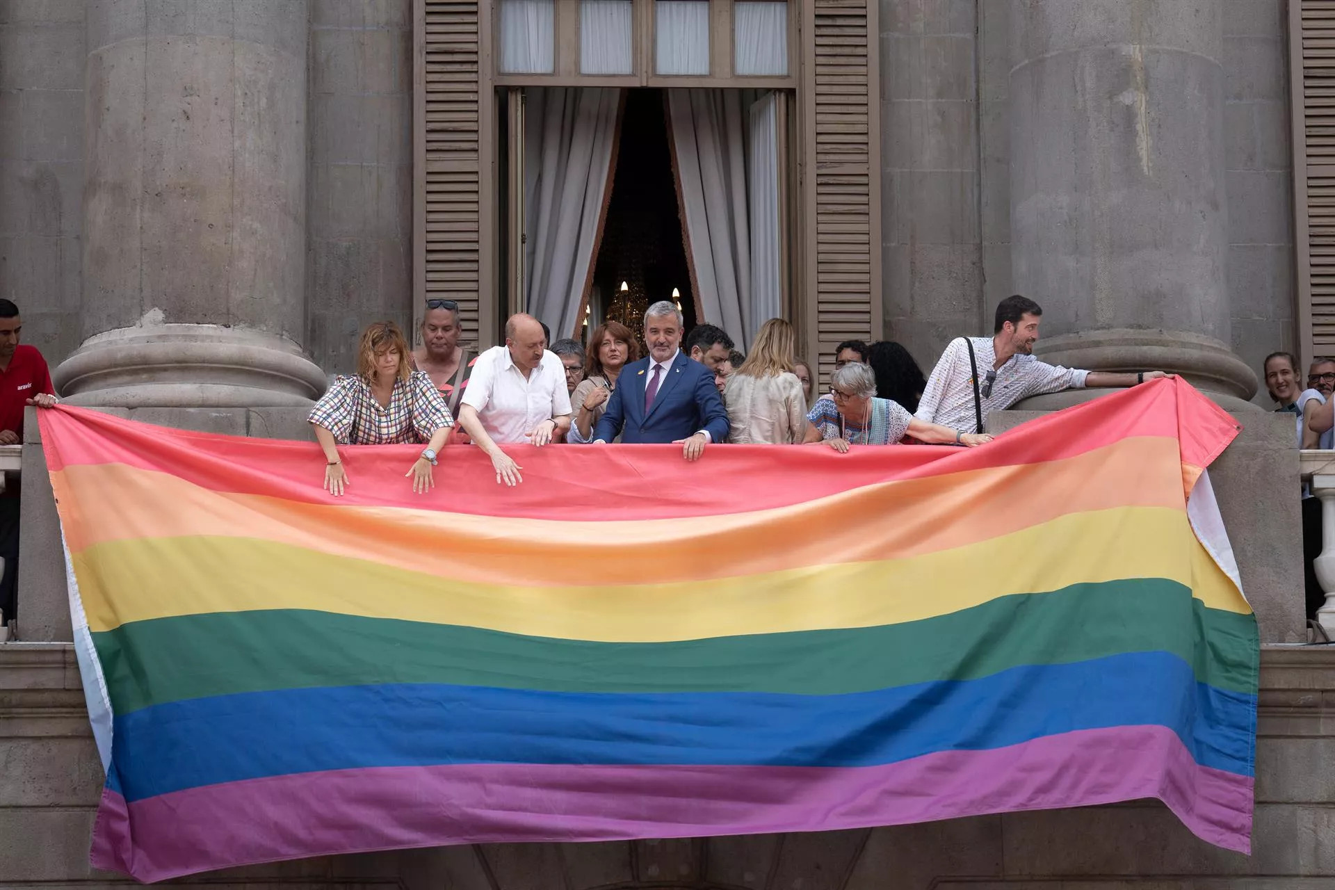 El alcalde Jaume Collboni ayuda a colgar la bandera LGTBIQ+ durante el Día del Orgullo / David Zorrakino - Europa Press