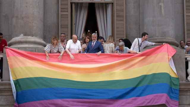 El alcalde de Barcelona Jaume Collboni ayuda a colgar la bandera LGTBIQ+ durante el Día Internacional del Orgullo en el Ayuntamiento de Barcelona / David Zorrakino - Europa Press