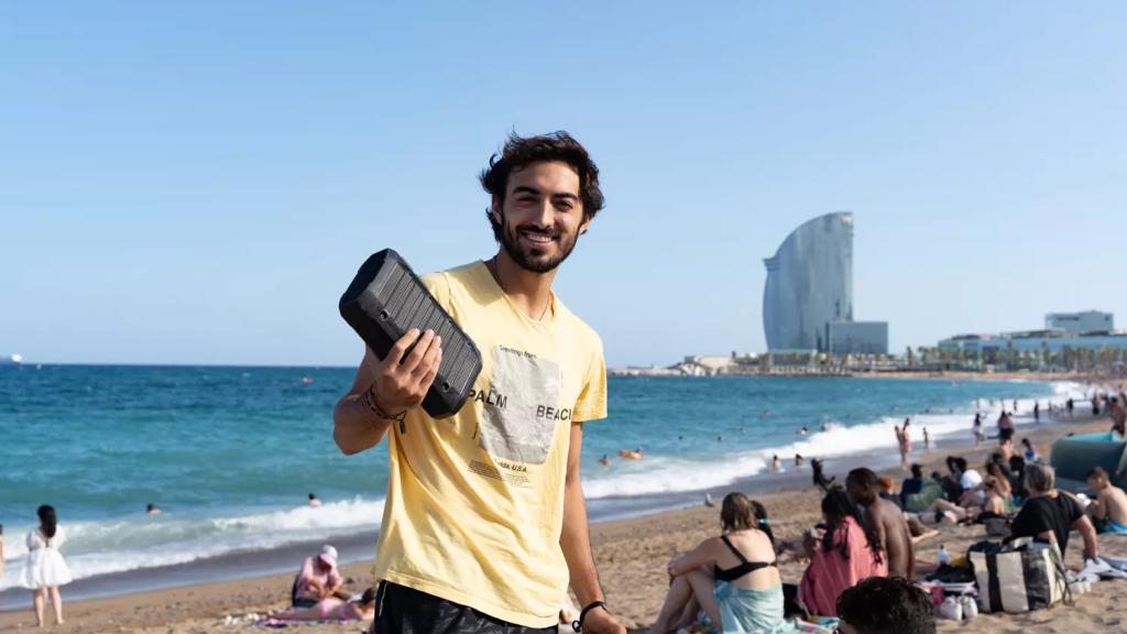 Un bañista en la playa de la Barceloneta con un altavoz