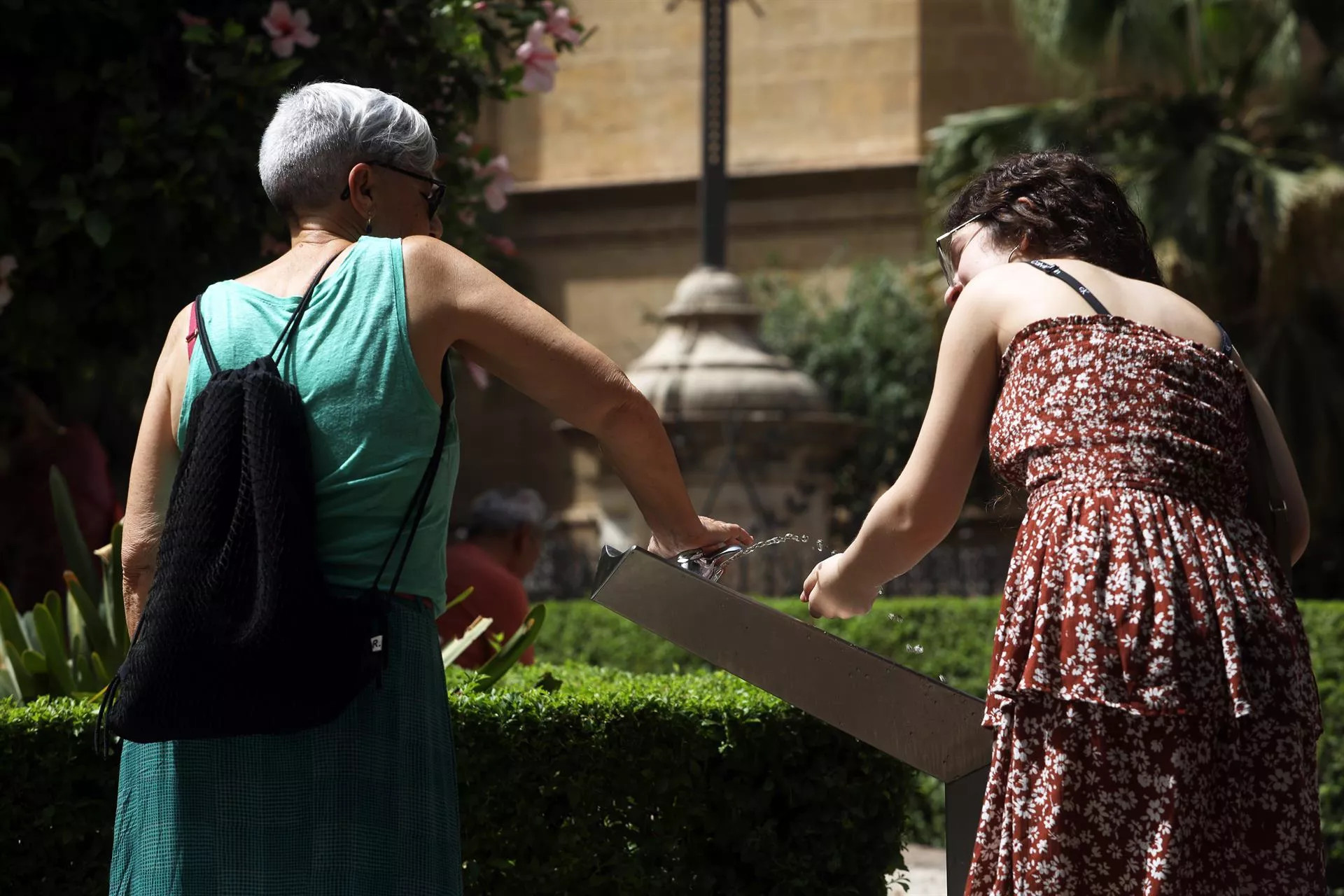 Dos mujeres recoge agua de una fuente para combatir la ola de calor / Álex Zea (EP)