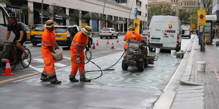 Operarios borran la pintura correspondiente al urbanismo táctico de la calle de Pelai / EUROPA PRESS