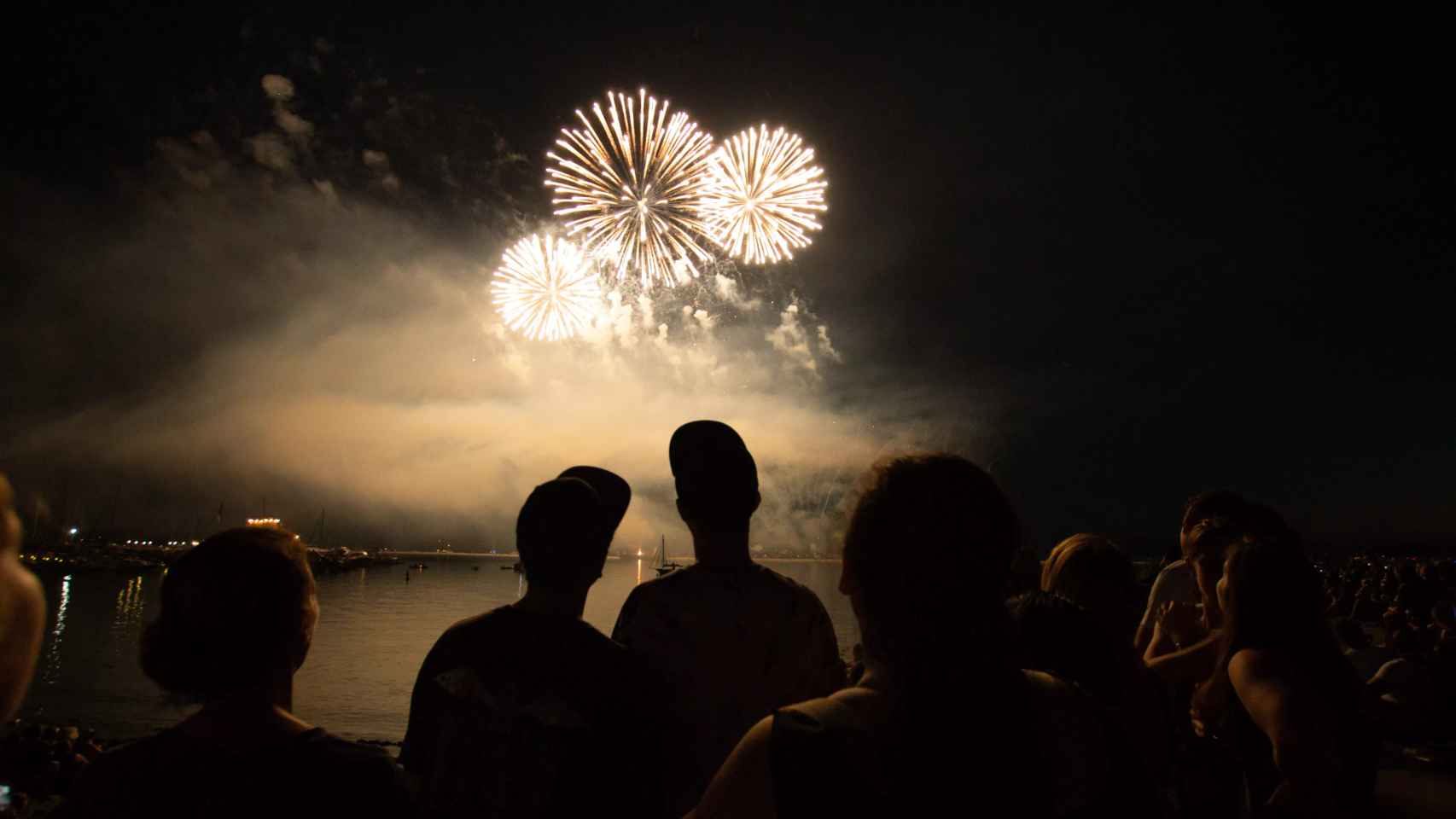 Gente contemplando los fuegos artificiales de una Fiesta Mayor / Unsplash