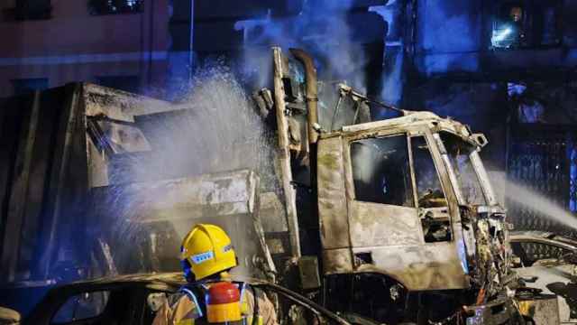 Bomberos apagando un camión de la basura incendiado en L'Hospitalet de Llobregat / BOMBERS