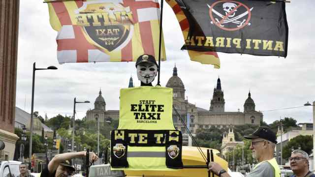 Pancartas y banderas de Élite Taxi durante una marcha lenta en Barcelona / David Oller - EP