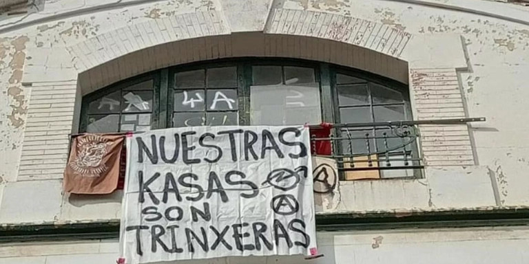 Cartel en una casa okupa de Barcelona 