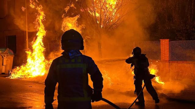 Los Bomberos apagando varios contenedores incendiados en Barcelona