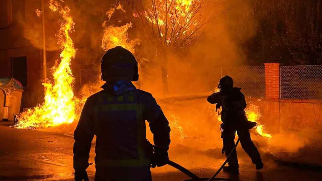 Dos Bomberos apagando un incendio por la noche