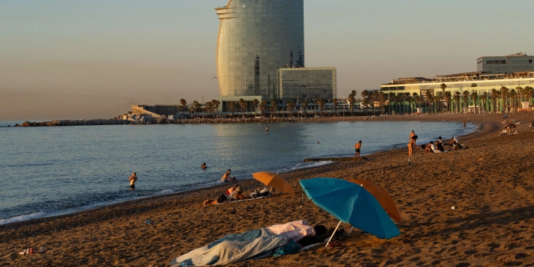 Gente durmiendo en la playa de la Barceloneta / LUIS MIGUEL AÑÓN