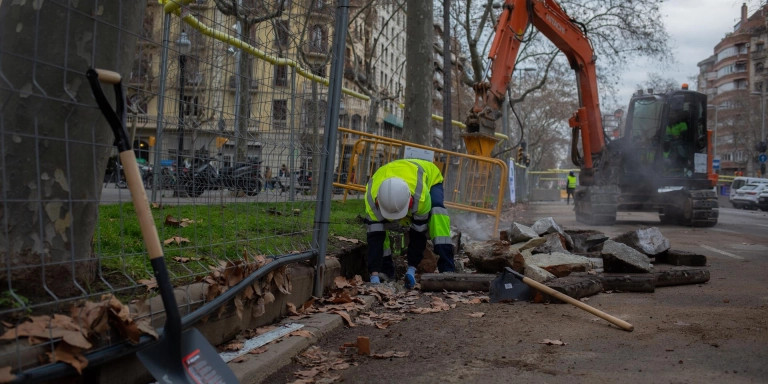 n obrero y una máquina excavadora trabajan en las obras para unir el tranvía por la Diagonal de Barcelona / EUROPA PRESS