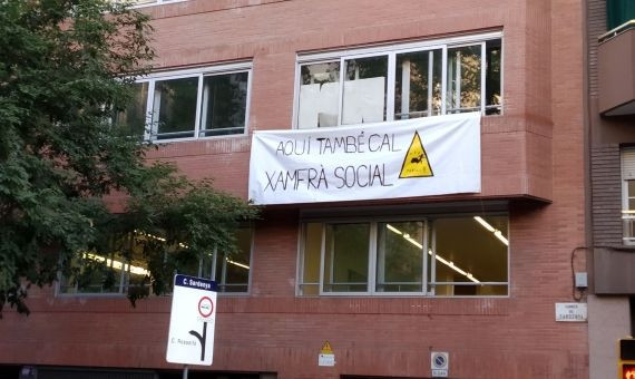 Pancarta sobre la escuela Sagrada Família en la que también se reclama el chaflán social / JORDI SUBIRANA