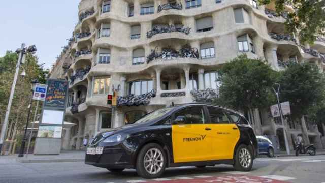 Un taxi circulando frente a la Pedrera en Barcelona