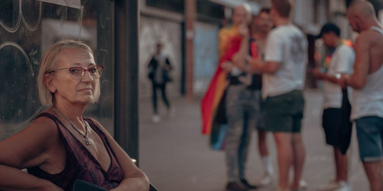 Una mujer posa delante de algunos asistentes del desfile del Pride / MARCELO RÍOS - @wolf_rios