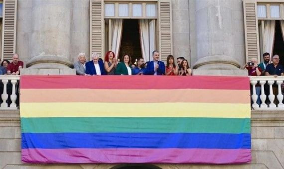 Ada Colau junto a otros concejales en el balcón del Ayuntamiento de Barcelona con el pendón LGTBI / EP