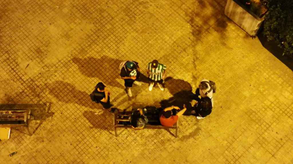 Jóvenes bebiendo en la plaza de la calle de Honduras de la Sagrera