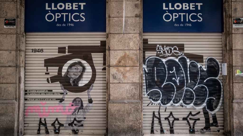 Persiana grafiteada de la tienda Llobet Òptics, en la Dreta del Eixample de Barcelona