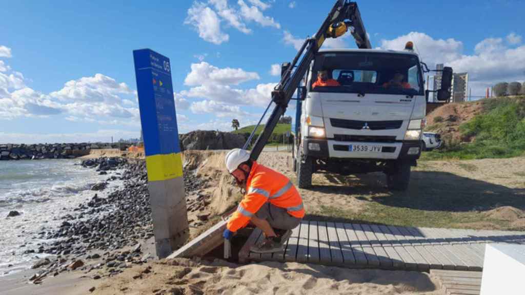 Técnicos de AMB desmontando la pasarela de una playa del área metropolitana