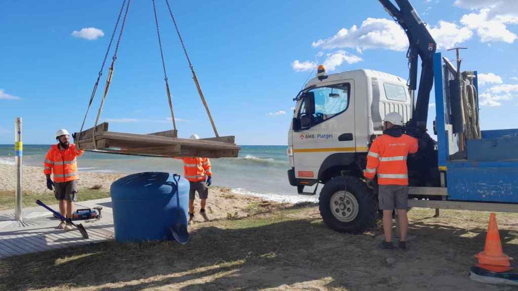 Técnicos de AMB desmontando la pasarela de una playa del área metropolitana