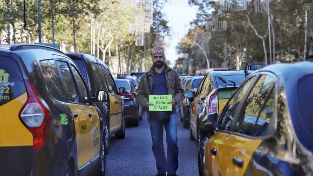 Un taxista protesta con un cartel para pedir justicia para Carlos, el taxista fallecido