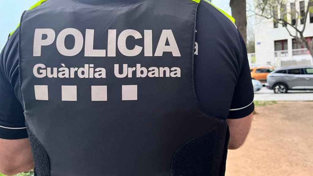 Uno de los agentes de la Guardia Urbana de Badalona de espalda